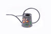 Grey watering can with picture of a flower on white background
