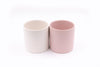 Two ceramic plant pots, one pink the other white