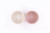 Top view of two ceramic plant pots with no drainage holes, one pink the other white