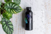 Clonex Clone Solution in black plastic bottle next to plant in pink pot
